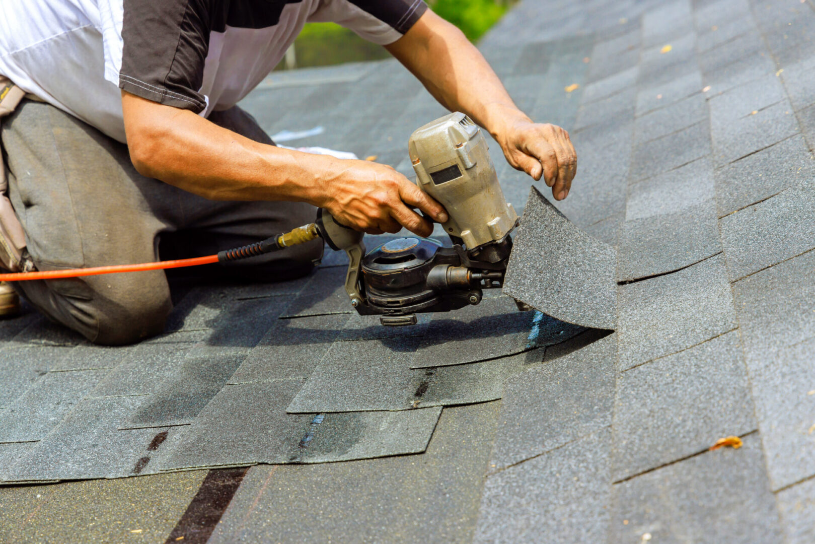 During installation of new bitumen shingles, construction roofer used a pneumatic air nail gun