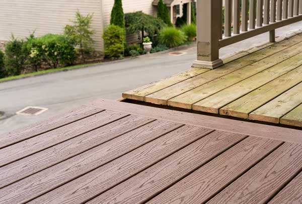 Wooden deck with a railing and a house in the background