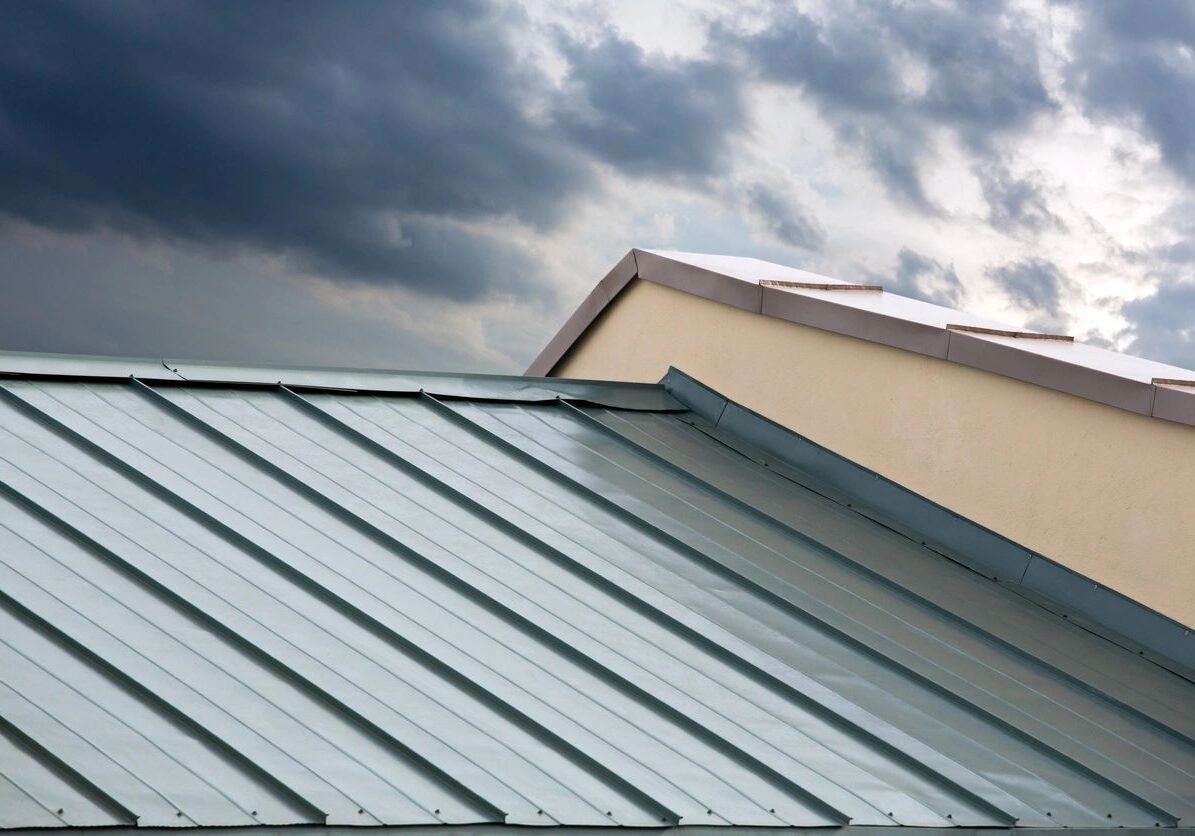 Building with a metal roof and a cloudy sky in the background