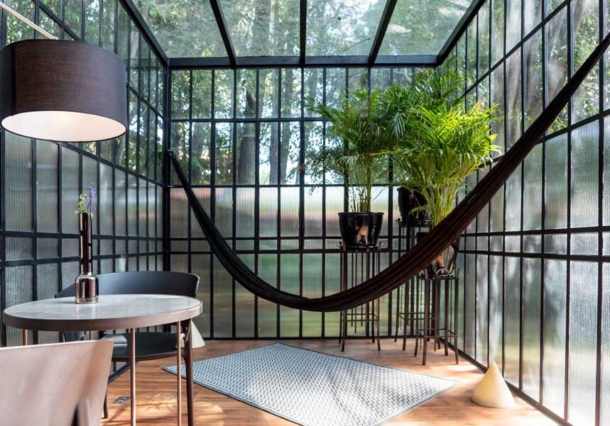 Room with a table and chairs in it, a flower vase on the table, a carpet on the floor